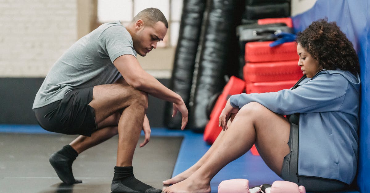 a man encourages a woman during an indoor gym training session